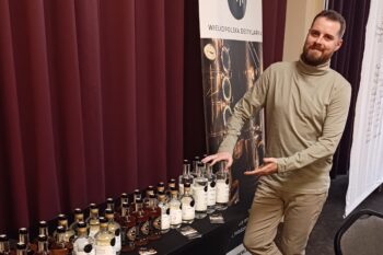 Tomek Kowalski przy stole degustacyjnym OVII przed wejściem gości do sali w hotelu Novotel Łódź Centrum.